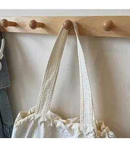 Detail of white canvas tote bag drawstring closure and durable reinforced stitching