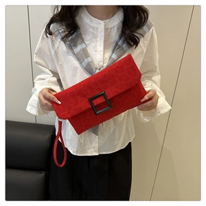 Detail of red leopard print clutch bag featuring a large black matte square buckle closure