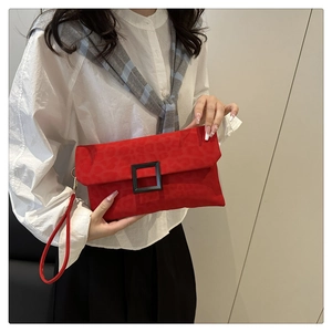 Detail of red envelope clutch with leopard texture and black square buckle