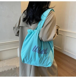 Close-up of sky blue drawstring tote bag with purple Webild print on wide shoulder strap