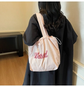 Detailed view of pink drawstring tote bag featuring stylish Wabild lettering and soft fabric