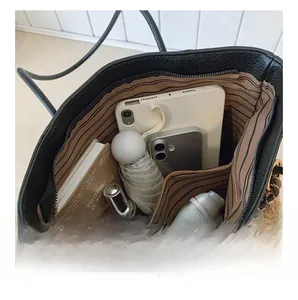 Detailed view of spacious black leather tote interior with striped lining and pockets