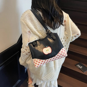 Fashionable black faux leather tote with apple illustration and red polka dot accents