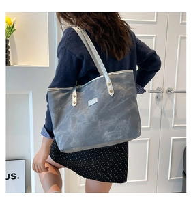 Dettaglio borsa tote grigia texture marmo con cinturini in pelle argento e rivetti