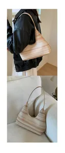 Detail of hand-woven straw tote bag with brown stripes and secure zipper closure