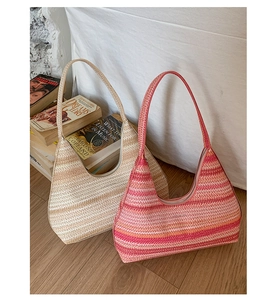 Detailed macro view of woven hobo bag material showing warm pink and beige stripes