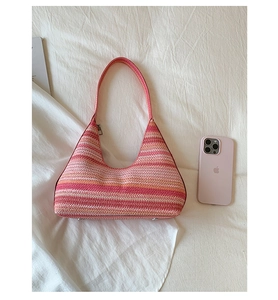 Detailed texture of multi-color striped woven straw hobo bag with zip closure