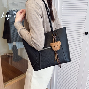 Large black pebbled leather tote bag with a cute bear charm and striped ribbon