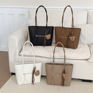 Large capacity tote bags in four colors with bear charms on a minimalist sofa