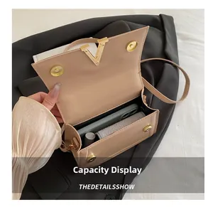 Detail view of the apricot flap bag showing interior capacity and golden V hardware