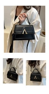 Detail of vintage black shoulder bag showing the gold V-clasp and fine leather texture
