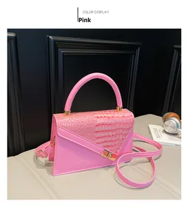 Detailed macro view of pink handbag with crocodile texture flap and gold metal hardware