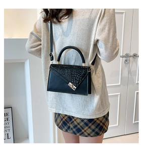 Detail of black stone pattern flap bag with gold metal twist lock and round handle