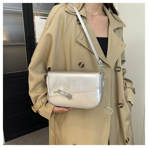 Close-up of matte silver saddle bag with unique metal link bar and slim shoulder strap