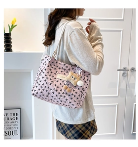 Pink tote bag detail with bow embroidery and cute teddy bear pendant on model