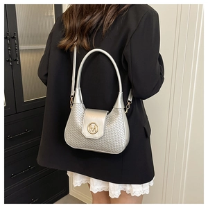 Silver woven shoulder bag with gold M buckle worn with black blazer and lace skirt