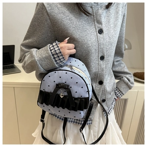 Detailed view of mini striped backpack with lace trim, heart print and bow pendant