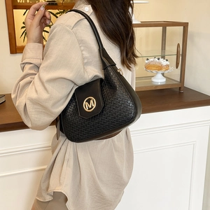 Women's black woven texture hobo bag with gold M logo and chain strap on model