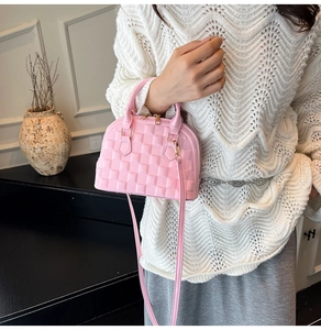 Detailed close-up of pink shell handbag with 3D cube texture and gold hardware