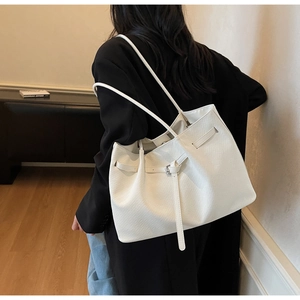 Detail of white large capacity tote bag with metal buckle and premium textured leather