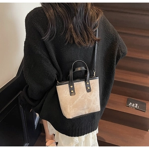 Model trägt eine Vintage-Canvas-Beuteltasche mit schwarzem Lederbesatz auf einer Treppe