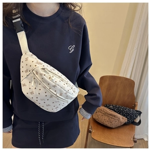 Détail de la sangle réglable et boucle sur un sac banane en velours à motifs de nœuds