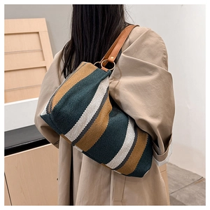 Detail of vintage striped canvas tote bag with leather shoulder strap and metal ring