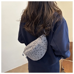 Détail d'un sac banane en velours côtelé gris avec motifs cœurs et nœuds sur un mannequin