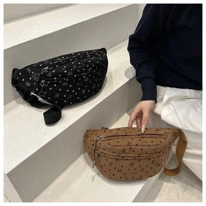 Detail of black and brown corduroy saddle bags with heart and bow prints on stairs