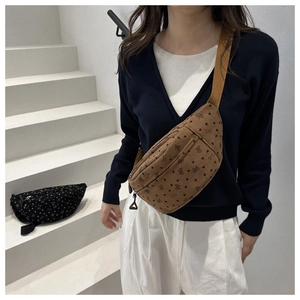 Detail of corduroy crossbody bag featuring heart patterns and adjustable strap