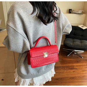Vue latérale du sac bandoulière rouge avec motif crocodile et fermoir métallique chic