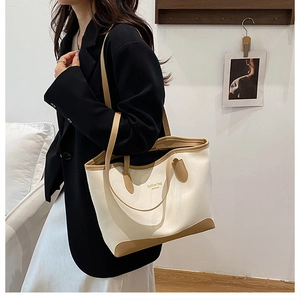 Photo lifestyle d'un sac cabas tendance avec deux poignées et des lettres dorées stylées