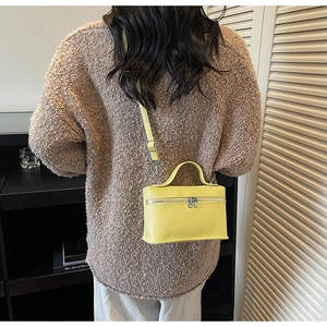Dettaglio borsa a scatola in pelle giallo vivace con zip argento e manico fisso