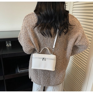Vista posteriore dettagliata della borsa a tracolla bianca texture litchi indossata da modella