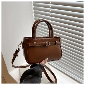 Détail du mini sac en cuir marron foncé avec boucle et crochets de sangle amovibles