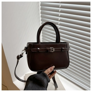 Détail du sac à main en cuir mat marron foncé avec boucle vintage et attaches métalliques