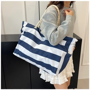 Detail of nautical blue and white striped canvas tote bag with thick rope handles