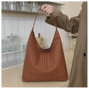 Detailed view of woven leather texture on a brown hobo shoulder bag for daily commuting