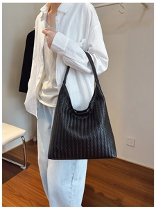 Detail of minimalist black hand-woven tote bag showing texture and craftsmanship