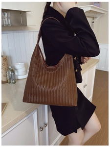Detailed close-up of dark brown woven texture on large fashion shoulder tote bag