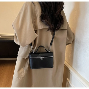 Vista posteriore di una modella con la borsa a tracolla in pelle martellata nera e zip argento