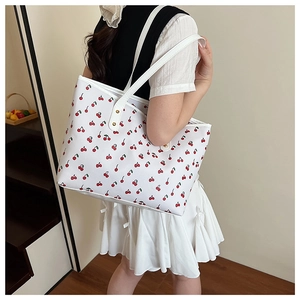 Detailed shot of cherry print tote bag on model showing large capacity and design