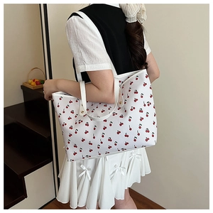 Close-up of the cherry print tote bag shown from a side view on a model for daily use