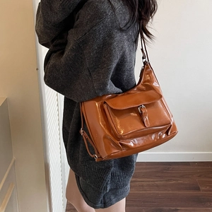Sac cabas marron en cuir brillant avec poche à boucle et détails métalliques