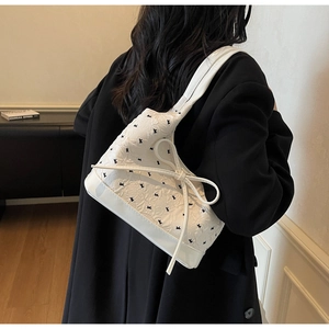Détail du sac à épaule en jacquard blanc avec broderie noire et un nœud décoratif élégant
