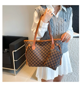 Dettaglio della borsa tote a scacchi con pochette coordinata e finiture in metallo dorato