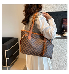 Vista dettagliata della borsa tote grande con motivo a scacchi sulla spalla del modello