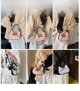Détail du nœud et du pendentif cœur sur le sac à bandoulière rose à pois et à volants