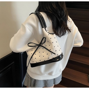 Détail de texture florale et imprimé lapin sur un sac sous le bras avec nœud décoratif