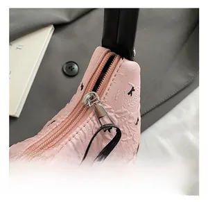 Vue détaillée de la fermeture éclair argentée et de la texture rose à nœuds du sac